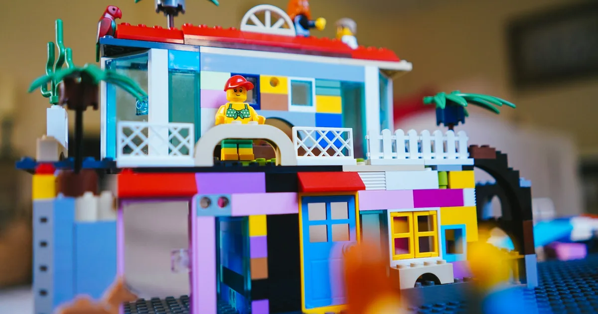 Detaljert LEGO-modell av et hus med veranda og gjerde