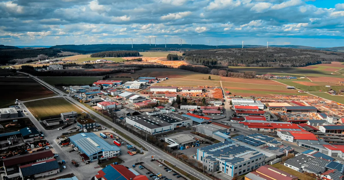 Industriområdet i en liten by sett fra lufta, med marker rundt
