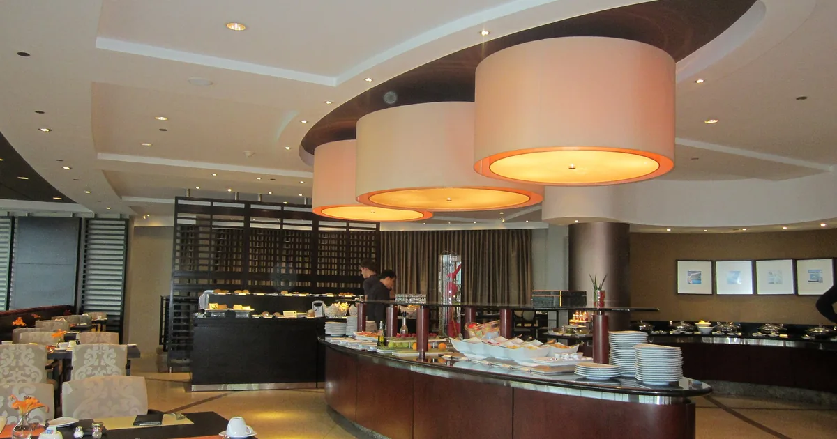 Frokostbuffet på et hotell med fat og skåler under runde taklamper