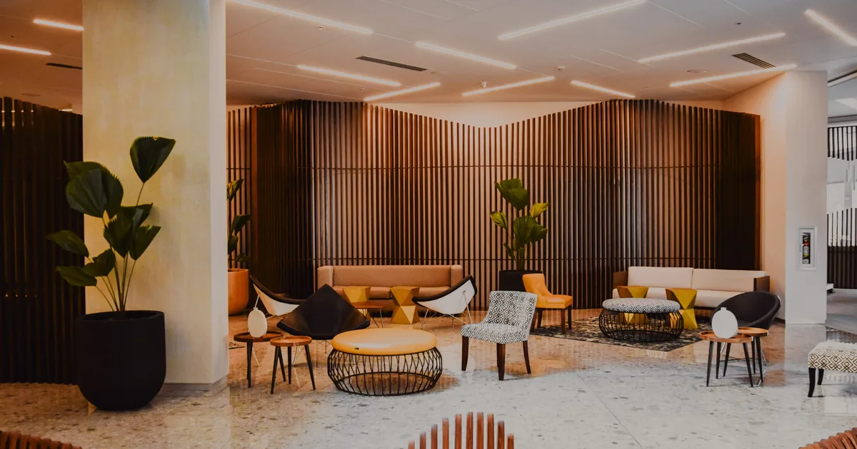 Hotellobby i skandinavisk stil med trelameller, lenestoler og planter